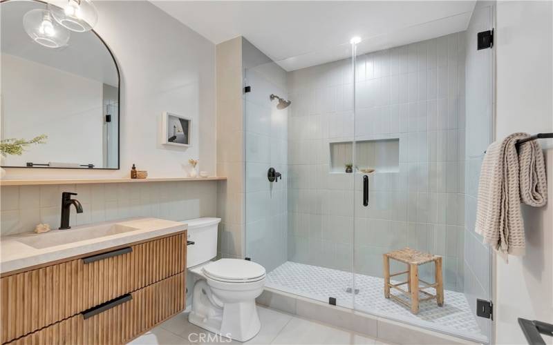 En-suite bathroom with large vanity, quartz counter, and frameless glass shower