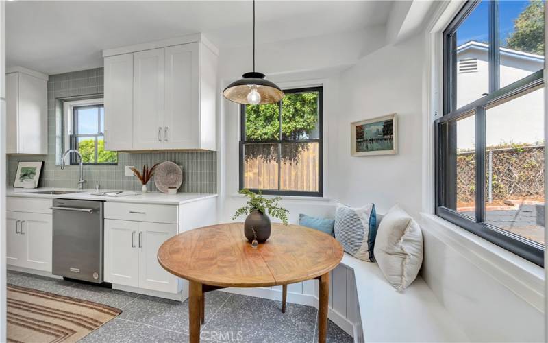 Breakfast nook with a built-in curved bench and an industrial pendant light