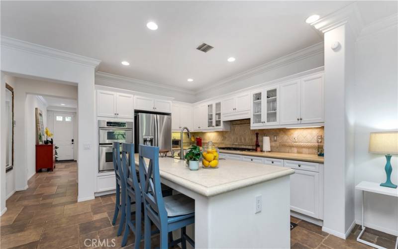 The gourmet kitchen boasts stainless steel appliances, sparkling white cabinets and a large kitchen island with Caesar stone countertops