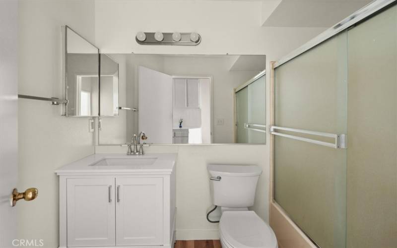 Hall bath with updated vanity, lights and flooring.