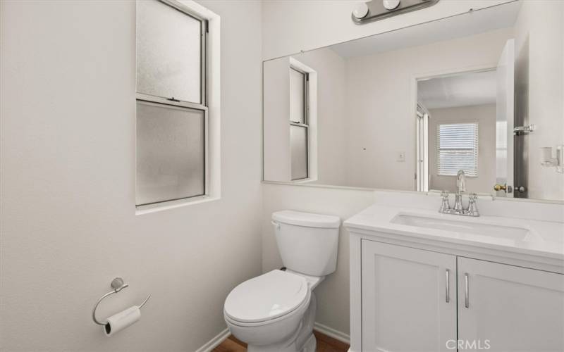 downstairs half bath with new vanity ,toilet lights and upgraded vinyl  flooring