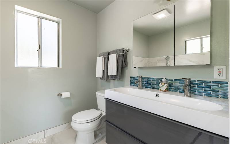 The primary suite bathroom is large and private with a large sink and dual fixtures.