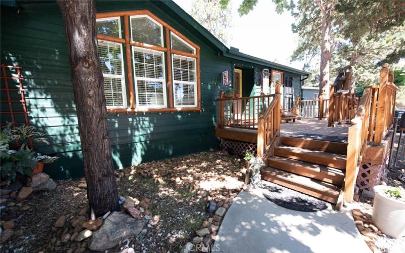 View of the large front porch deck leading to the front door and the private separate entrance to the primary bedroom.