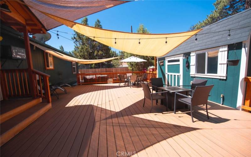 This deck is very spacious.  Plenty of space for the firepit with 4 chairs near the front and still room for the umbrella covering another table with chairs in the back of the deck.  Patio lights provide a peaceful environment at night!