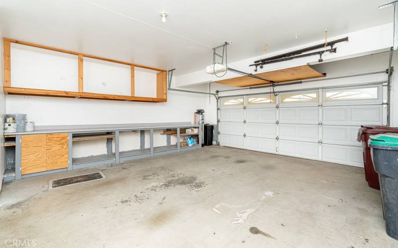Spacious garage with work bench and cabinets