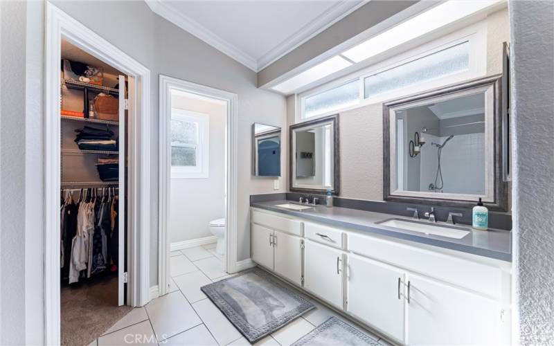 Primary bathroom with dual sinks and walk-in closet