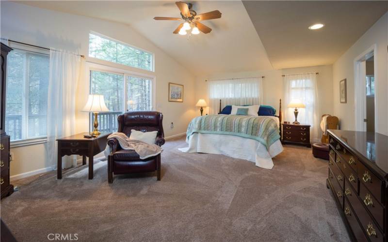 The primary bedroom is spacious, private and has a deck overlooking the stunning pines and creek below.