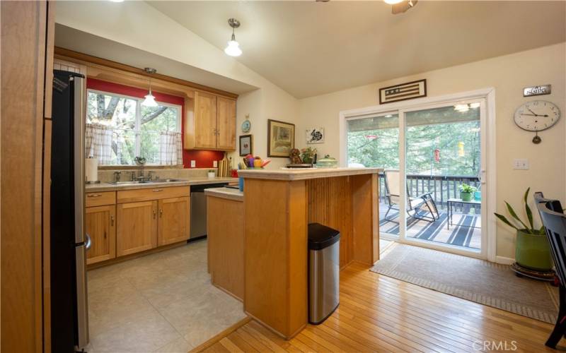 The kitchen has maple cabinets, tile counter tops and an island.