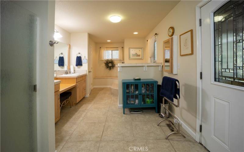 Primary bath has a soaking tub and separate shower, two sinks and a vanity between.
