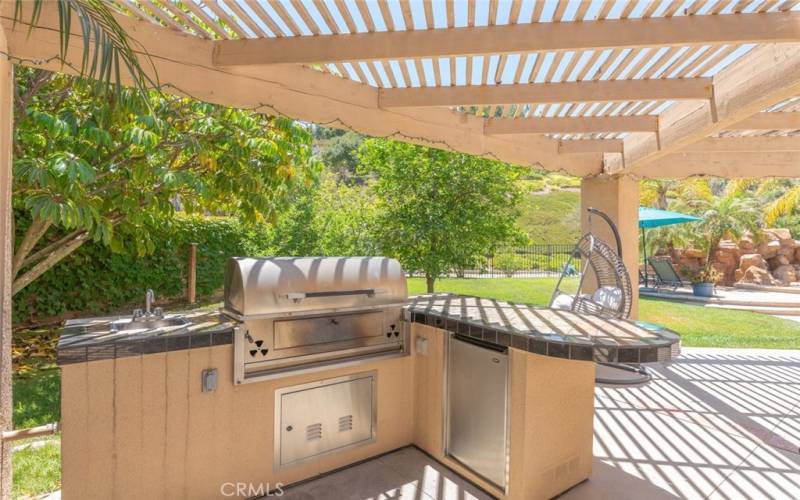 Outdoor kitchen with built-in BBQ and ample counter space, perfect for cooking and entertaining.