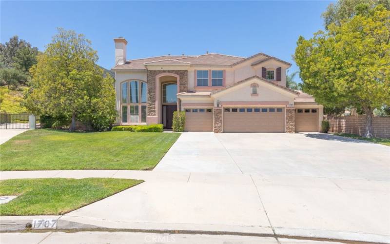  
Beautiful home with exceptional curb appeal, featuring a well-manicured lawn, elegant facade, and a spacious driveway.