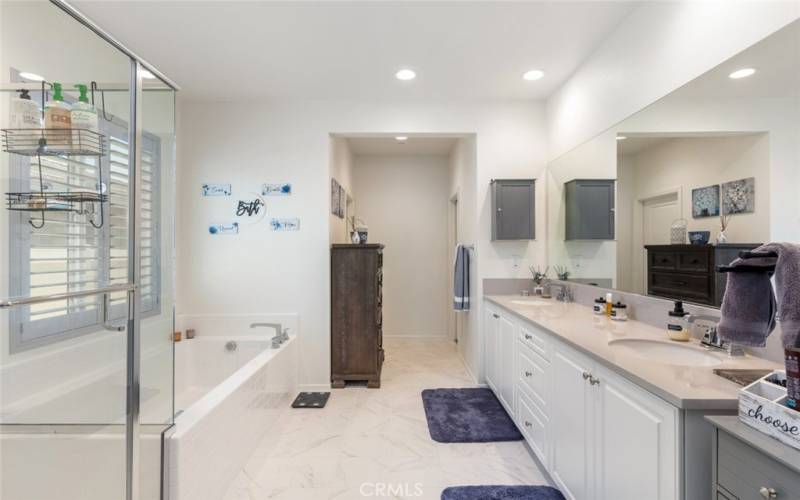 This spacious bathroom boasts a generous layout with ample room for both a large vanity and a separate soaking tub.