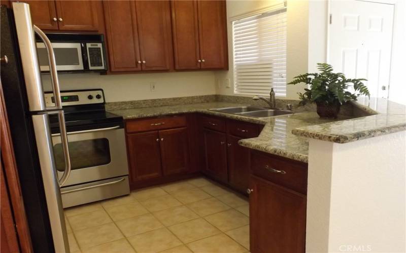 Kitchen has granite counters, stainless stove, refrigerator, microwave and dishwasher.