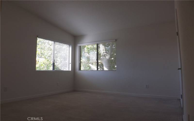 2nd bedroom has windows wih sun screens and a nice shade tree outside.