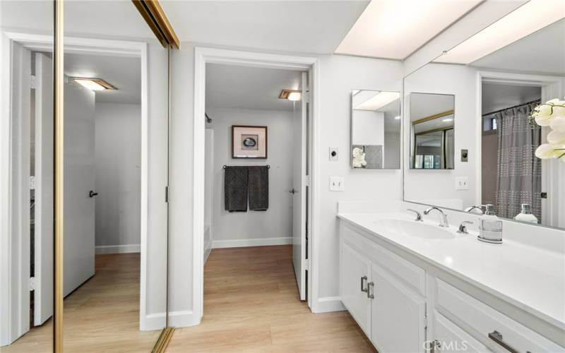 The primary bathroom features a tub with a shower above and a dressing area/vanity.