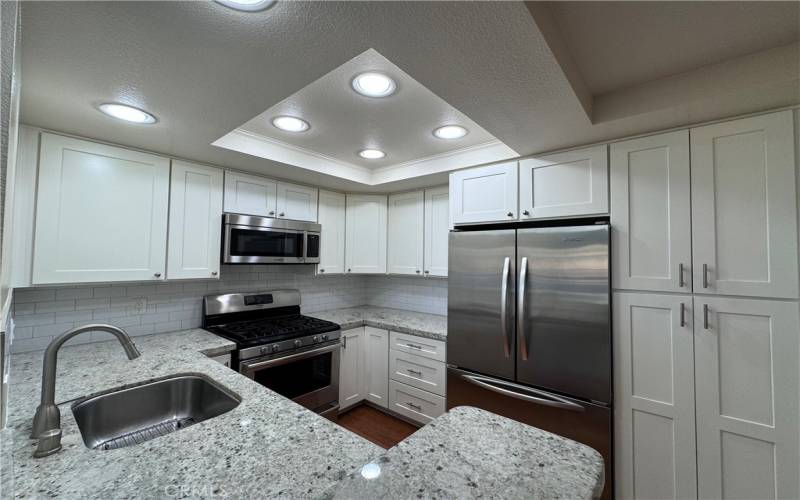 Gourmet Kitchen with SS appliances, quartz counters, and white cabinetry!