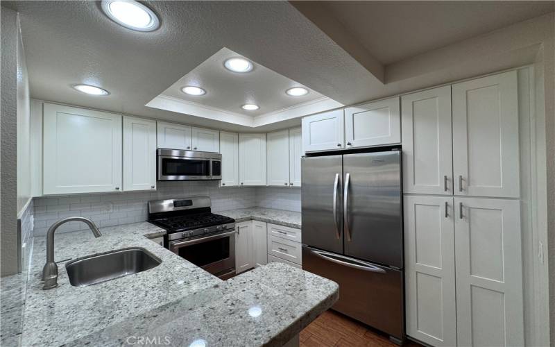 Gourmet Kitchen with SS appliances, quartz counters, and white cabinetry!