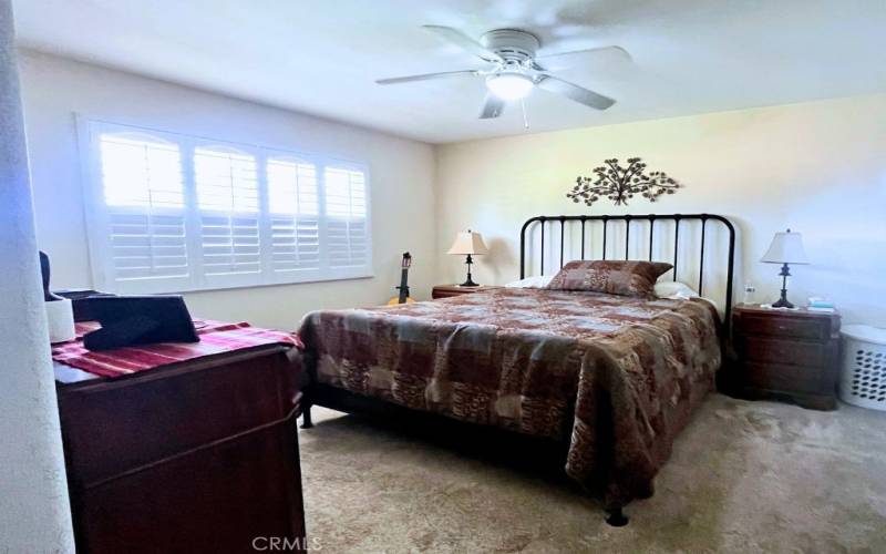 Primary Bedroom with ceiling fam, plantation shutters and 2 closets.