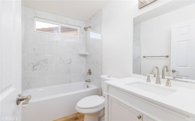 Completely remodeled hall bath with new; vanity, mirror, medicine cabinet, lighting & hardware.  Marble countertop with new toilet. Brand new custom tiled shower/tub.