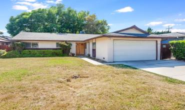 The front yard with its sprawling lawn, colorful planters and well-trimmed hedges enhance its eye-catching curb appeal.