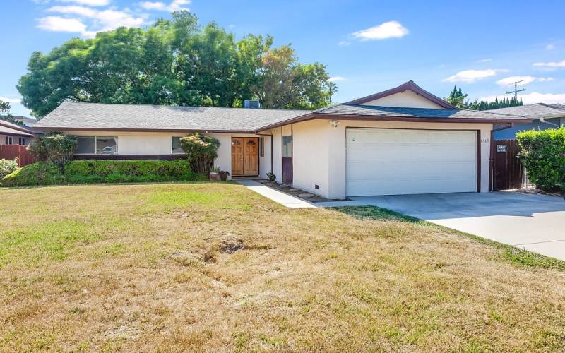 The front yard with its sprawling lawn, colorful planters and well-trimmed hedges enhance its eye-catching curb appeal.