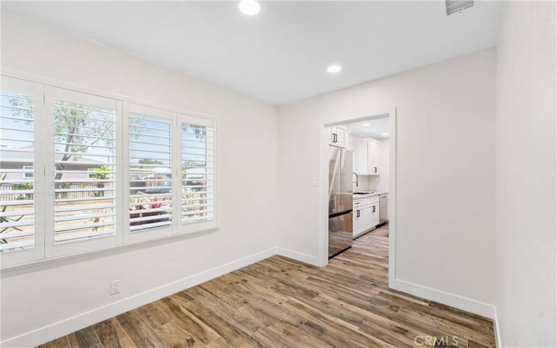 Dining room off kitchen with white wood shutters