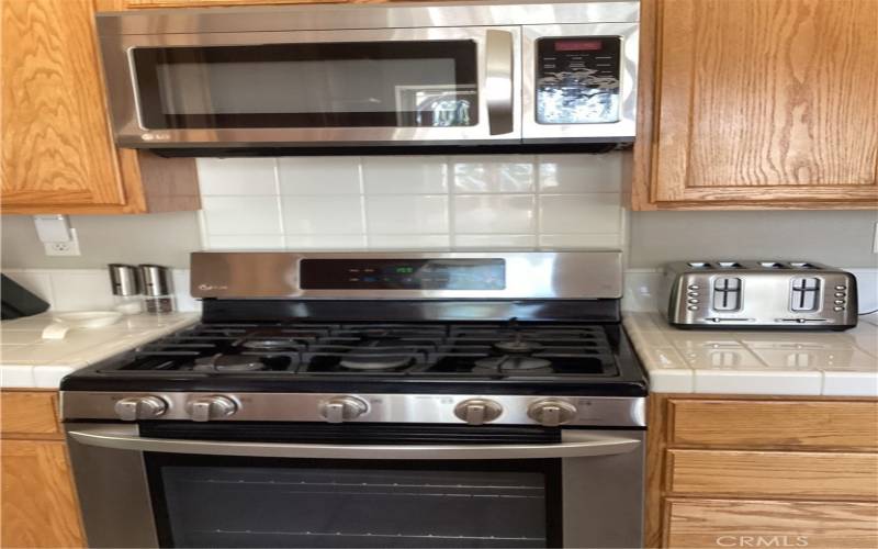  Note the cabinets on both sides of the stove and the microwave above