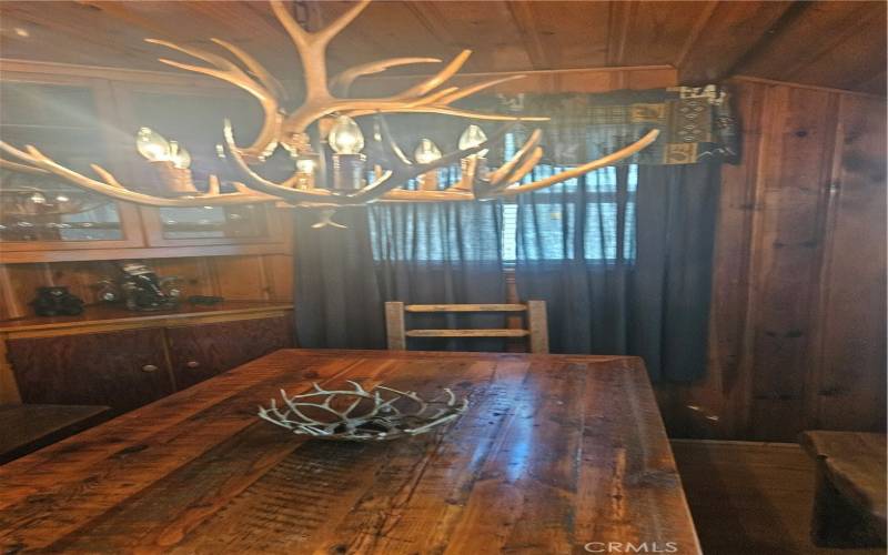 A view of the antler chandelier looking over dining table in kitchen