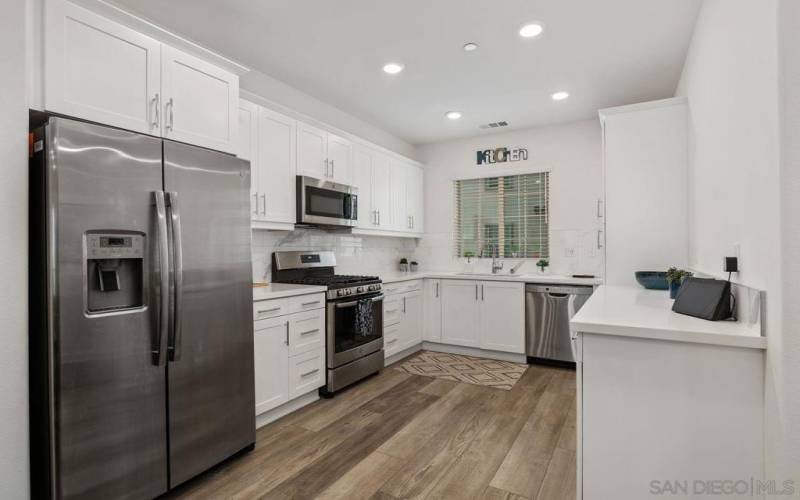 Gourmet kitchen is located on the main level and features high end design, beautiful quartz countertops, custom finishes and GE stainless steel appliances.