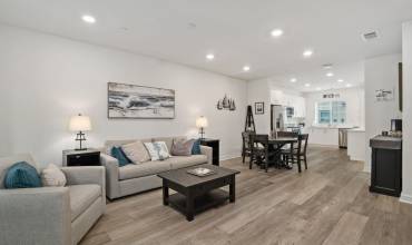 Living room with an open floor plan, located on the main level. Luxury vinyl flooring throughout.
