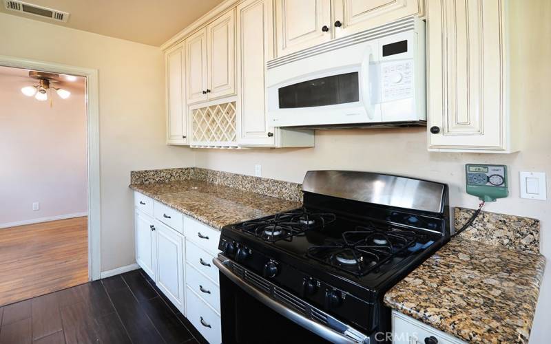 Kitchen with microwave, granite, and a built in wine rack!