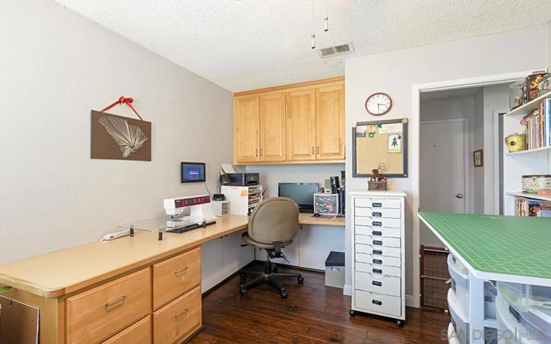 One bedroom with built-in cabinets and desk is currently being used as a sewing/hobby room.