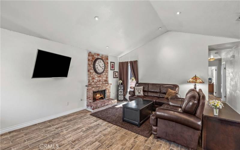 View from front door.  High ceiling with indirect lighting and cozy fireplace.