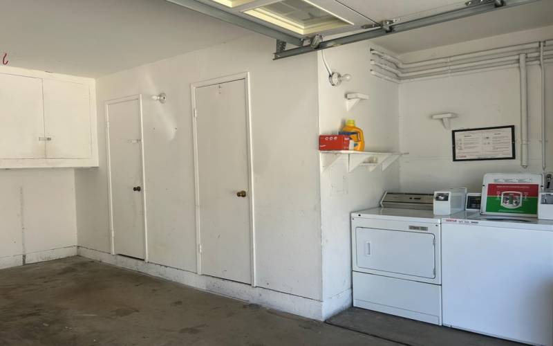 Interior space of shared 2 car garage with storage closet and laundry.