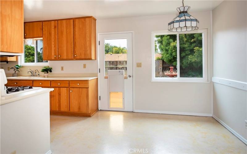 Dining area in kitchen with pet door that is securable to back patio.