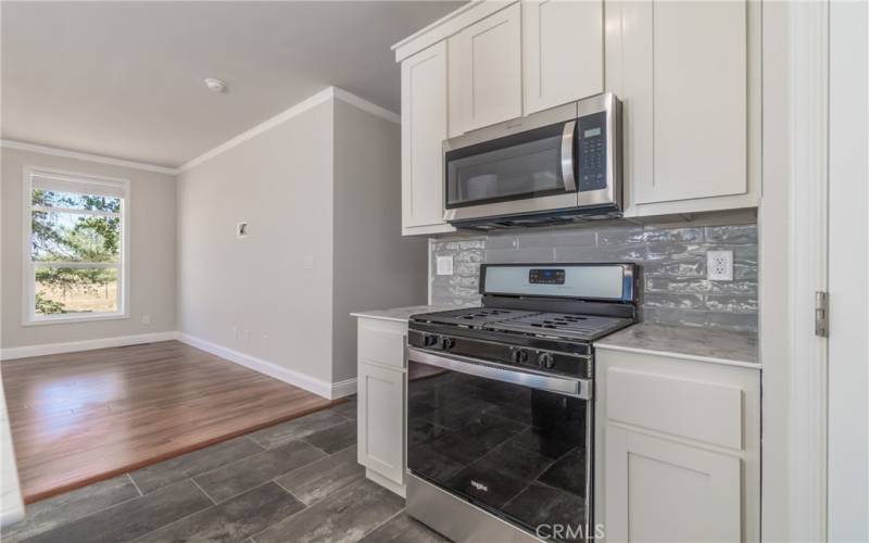 Custom tile backsplash, stainless steel propane range & microwave