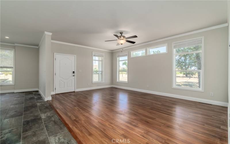 Spacious living room with large windows & a wall set up for an entertainment center