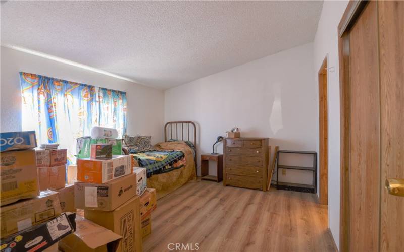 The primary bedroom boasts laminate wood floors, a vaulted ceiling and a walk in closet.
