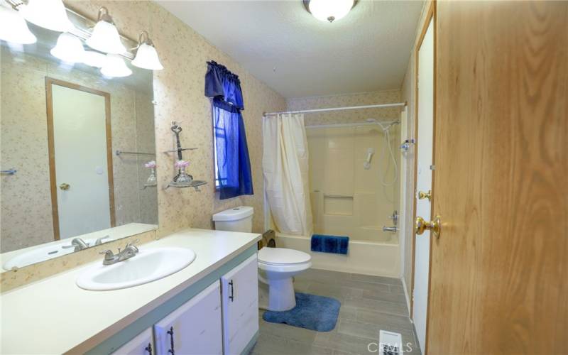 The ensuite bathroom features tiled floors, spacious vanity, tub/shower combination and a linen cabinet.