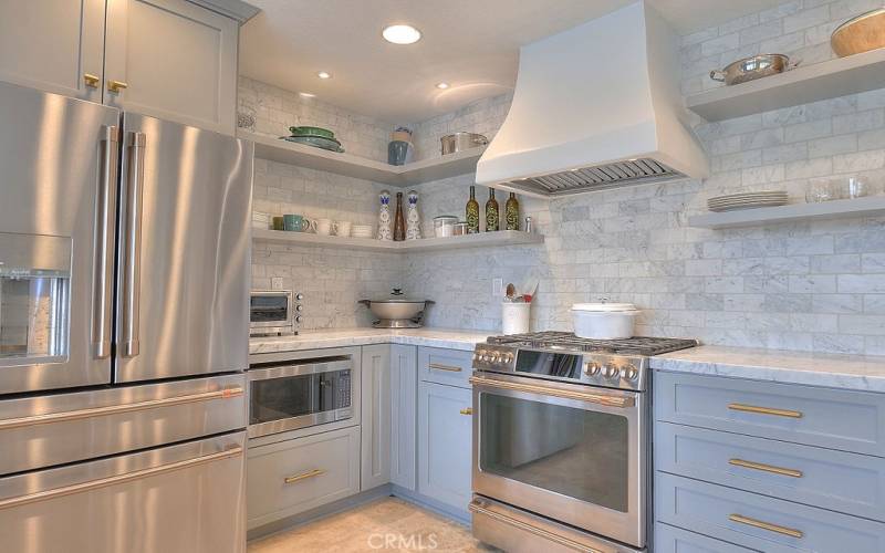 Sleek and stylish gourmet kitchen with tiled backdrop with recessed lighting and rich cabinets makes cooking every day a pleasure