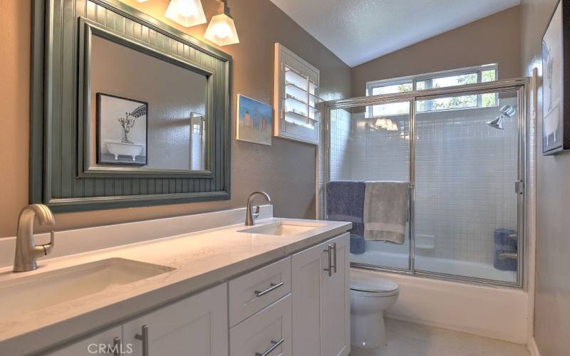 Updated granite double sinks and classic cabinetry in the bright upstairs bathroom