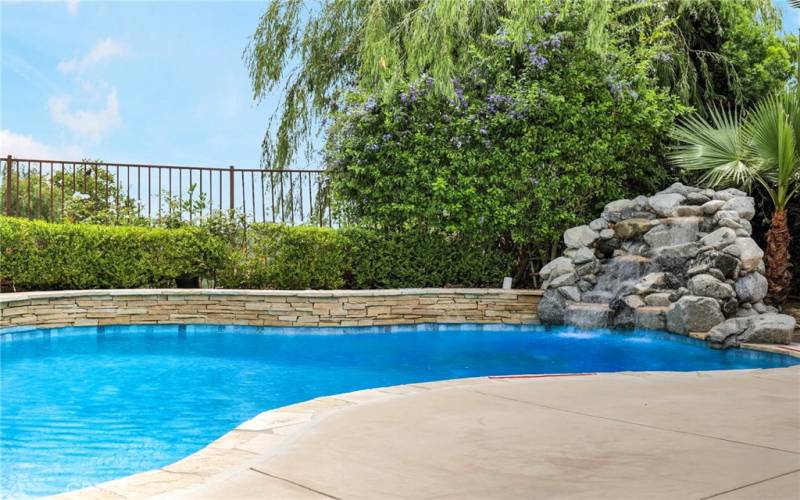 Relax in this dreamy one of a kind yard with swimming pool with water fall