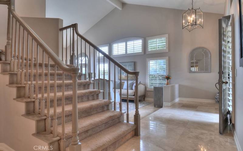 Complete with a grand entryway with a wooden staircase and cathedral ceilings immediately draws you into this spacious two story home