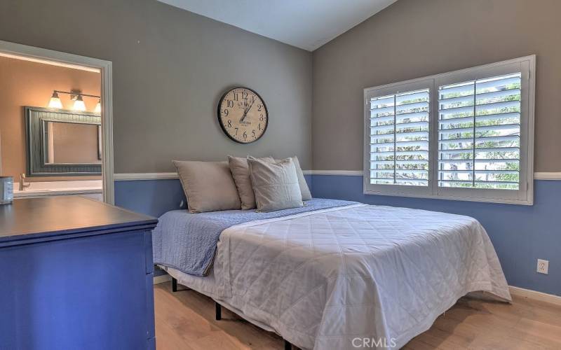 Cozy upstairs bedroom with plantation shutters on the window and beautiful wood floors