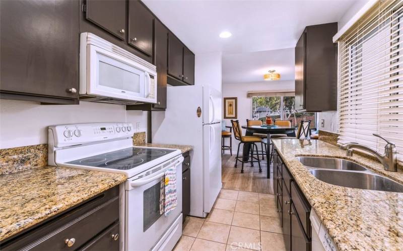 Updated and Dining area with an elegant high-top table and chairs with view of the trails fully equipped kitchen with fridge, dishwasher and microwave.
