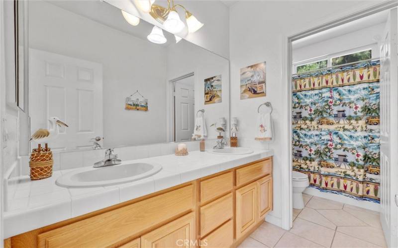 Hallway Bathroom with double sink vanity and separate bathroom.