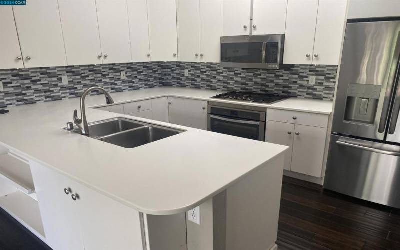 Stainless steel appliances, including gas cooktop.