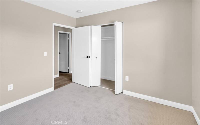 Bedroom 3 with low pile carpet and backyard view