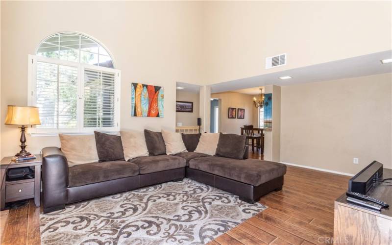 Livingroom with arched window.  Open to dining room and kitchen area.