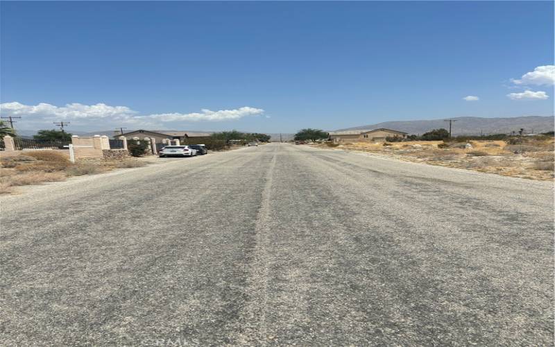 Road view, nearby homes, utilities nearby.